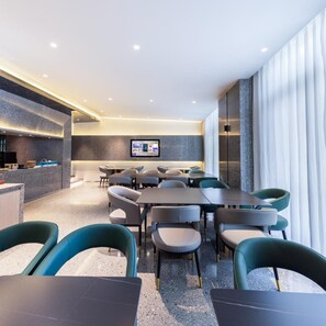 A modern dining area with tables and chairs, a counter, and a large window with curtains. - Atour X Hotel, Majiabao Metro Station, Beijing South Railway Station (Beijing)