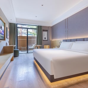 A modern hotel room with a large bed, a desk, a chair, and a view through a sliding door. - Atour X Hotel, Majiabao Metro Station, Beijing South Railway Station (Beijing)