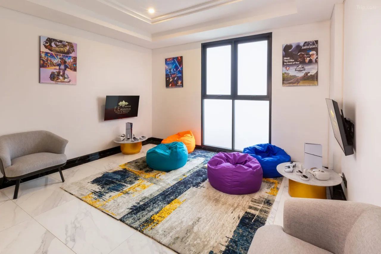 Una sala moderna con un sofá, pufs, una mesa de centro y un televisor.