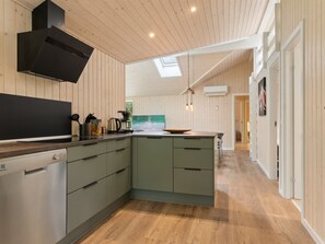 Une cuisine moderne avec des murs en bois, une verrière et un îlot central.