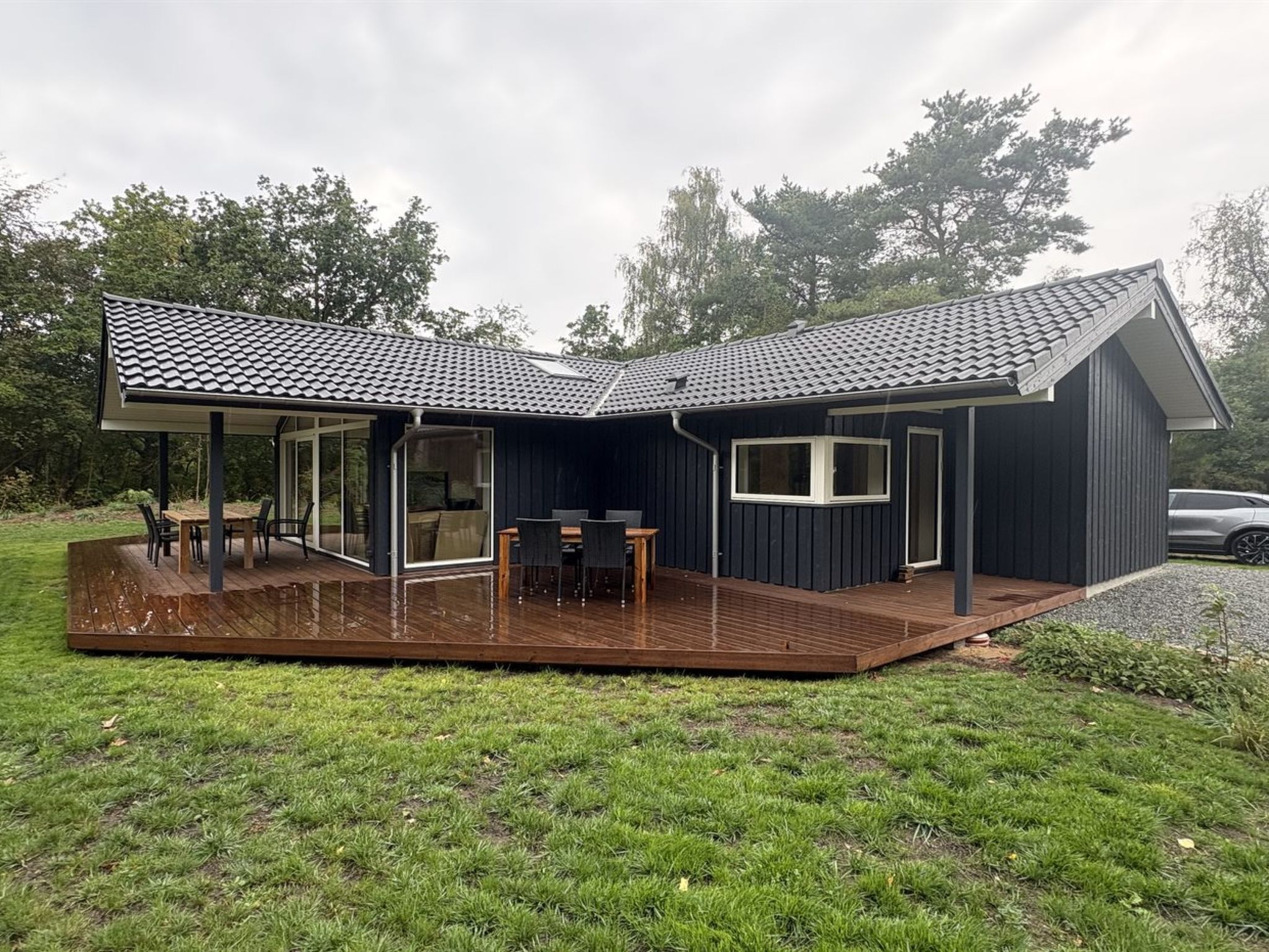 Une maison moderne dotée d’un patio couvert, d’un coin repas et d’un garage.