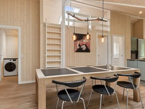 Eine moderne Küche mit einem Holztisch, vier Stühlen und einer Hängeleuchte.