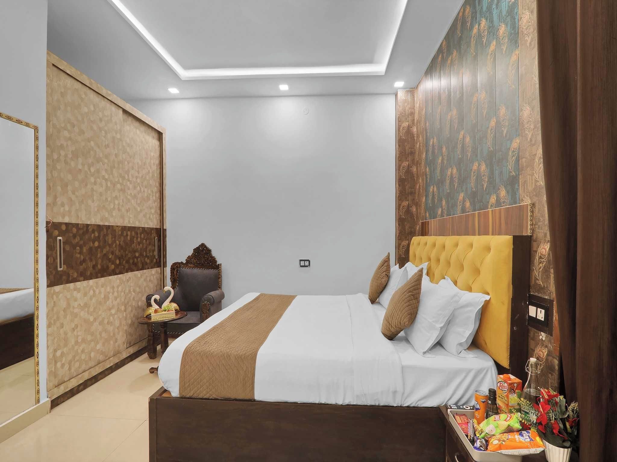 Un dormitorio moderno con una cama grande, un armario, una mesita con una silla y un panel decorativo en la pared.