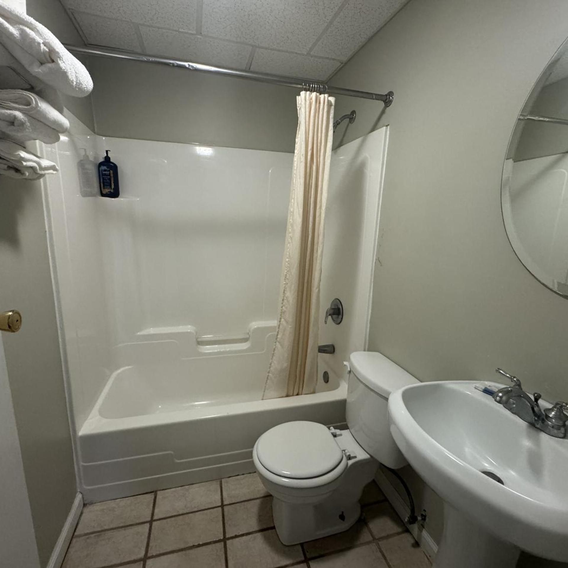 A bathroom with a bathtub, toilet, and sink.