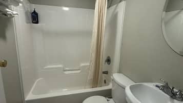 A bathroom with a bathtub, toilet, and sink.