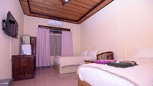 Un dormitorio con dos camas, techo de madera, armario, televisor y ventana con cortinas.