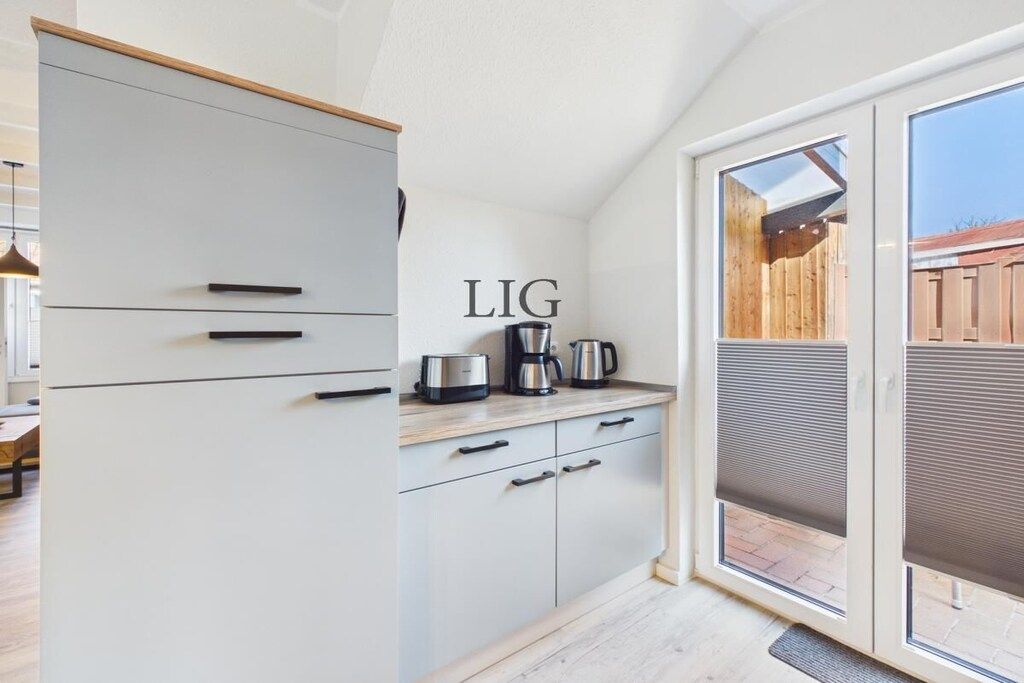 Une cuisine avec une porte-fenêtre coulissante donnant sur un espace extérieur.
