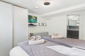A hotel room with a bed, a TV, and a mirror. - Holiday apartment Salzwiese (Langeoog)