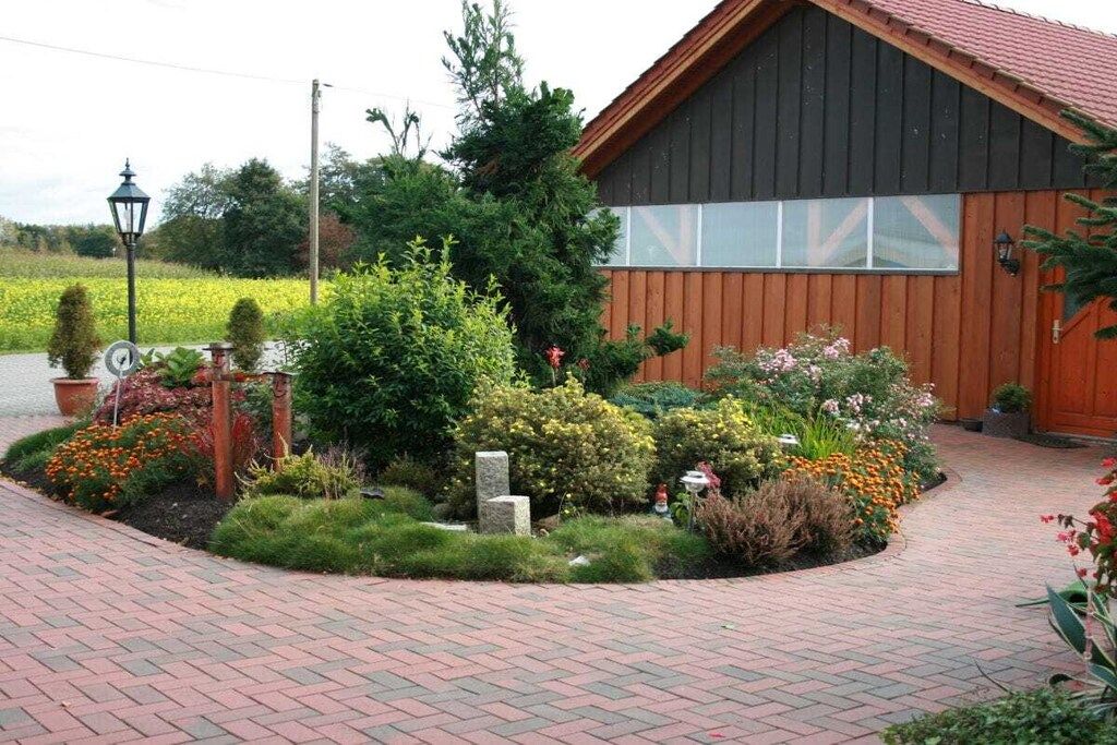 Un bâtiment à l’extérieur en bois, avec un chemin en briques menant à l’entrée.