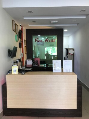 Una recepción con un letrero que dice 'Viva Hotel' al fondo.