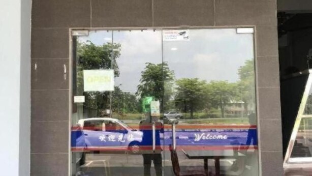 A glass door with a 'Welcome' sign, a 'OPEN' sign, and a reflection of a car and trees. - Viva Hotel SRI Aman (Sri Aman)