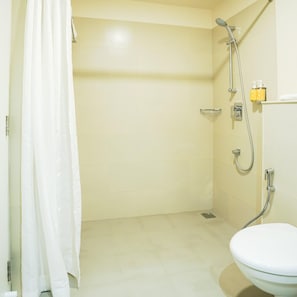 Un baño con ducha, inodoro y un perchero para toallas.