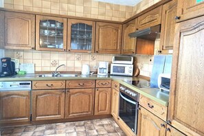 Eine Küche mit Holzausstattung, einer Mikrowelle, einem Toaster und einem Geschirrspüler.
