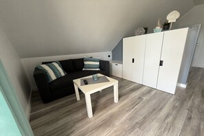 A modern living room with a sofa, a coffee table, and a wardrobe. - Friesenkoje Horumersiel - bunk 3 (Wangerland)