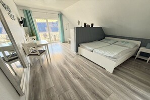 Een slaapkamer met een bed, een bureau en een stoel.