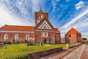 Eine Kirche mit einem markanten Turm und einer traditionellen Backsteinfassade.