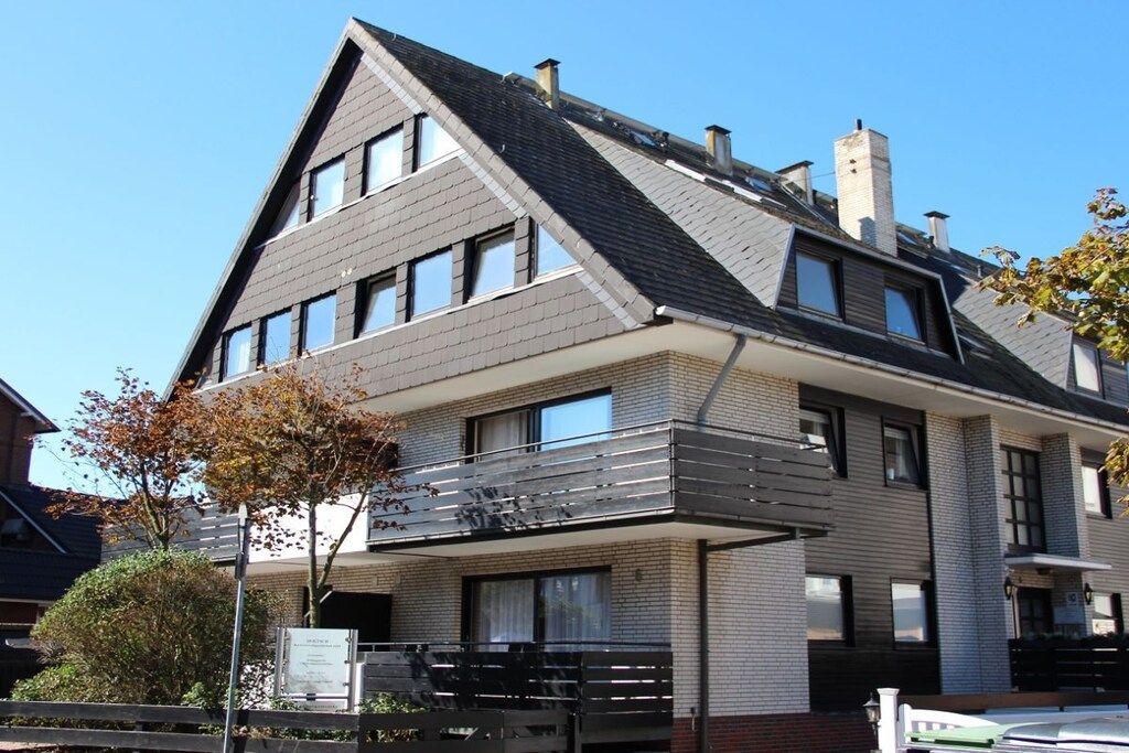 Un bâtiment moderne à deux étages, doté d’un toit en pente, de nombreuses fenêtres et d’un balcon.