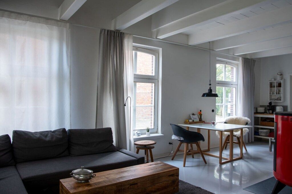 Un espacio habitable moderno con sofá, una mesa de comedor y una zona de cocina.