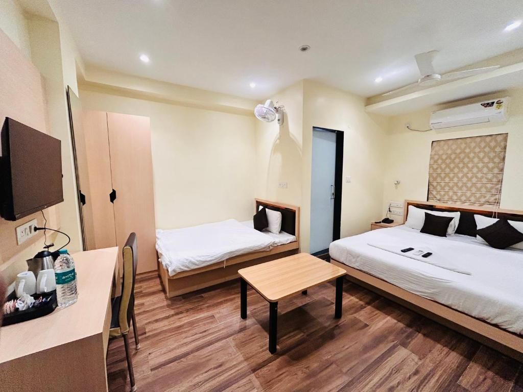 A hotel room with two beds, a desk, and a chair.