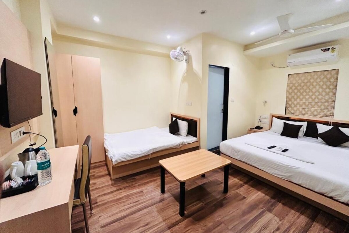 A hotel room with two beds, a desk, and a chair.