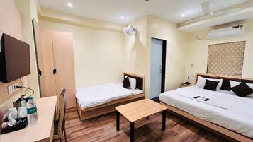 A hotel room with two beds, a desk, and a chair.
