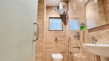 A bathroom with a toilet, sink, and shower.