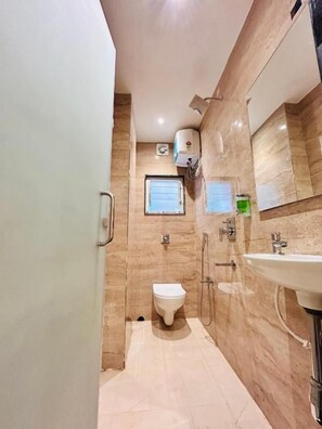 A bathroom with a toilet, sink, and shower. - Hotel Golden Square (Kolkata)