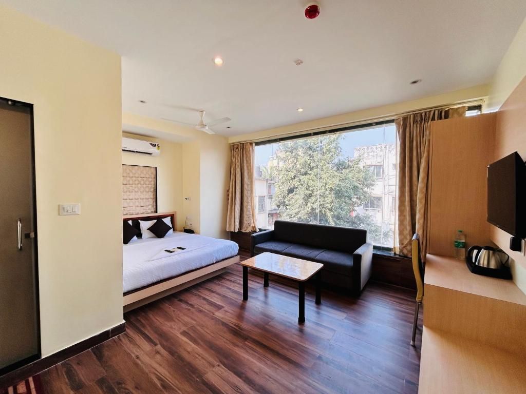 A hotel room with a bed, sofa, and a small table.