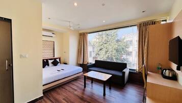 A hotel room with a bed, sofa, and a small table.