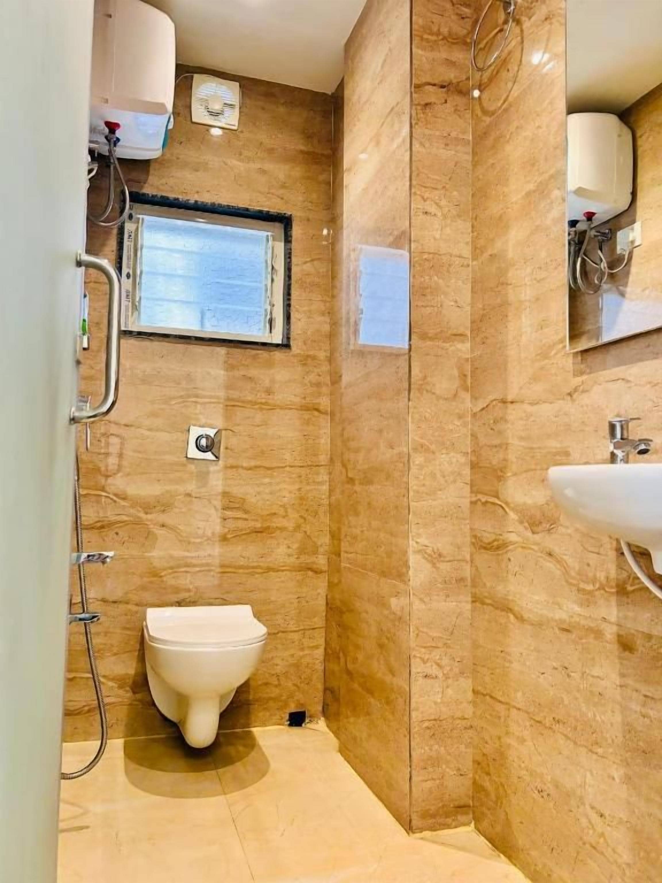 A bathroom with a toilet, shower, and sink.