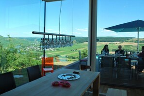 A dining area with a table set for two, overlooking a scenic landscape. - "Bernkastel Moselle Panorama" (Bernkasel-Kues)