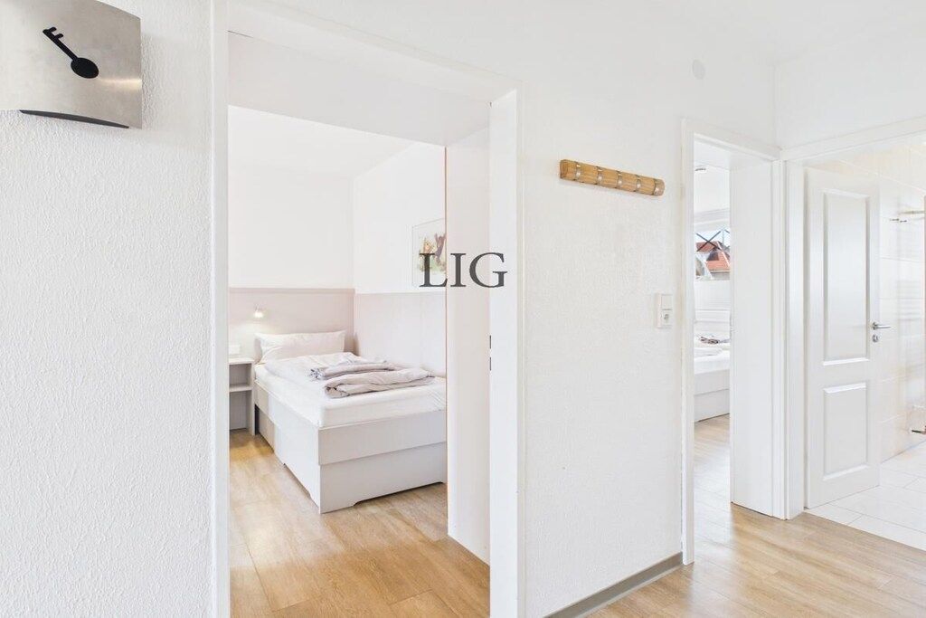 Une chambre à coucher moderne, avec un lit, une table de chevet et un luminaire fixé au mur.
