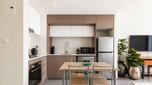 Una cocina moderna con comedor, electrodomésticos de acero inoxidable y un diseño minimalista.
