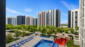 Un área de piscina en la azotea con sillones de descanso y una piscina.