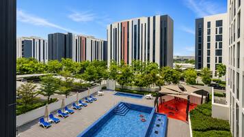 A rooftop pool area with lounge chairs and a swimming pool.