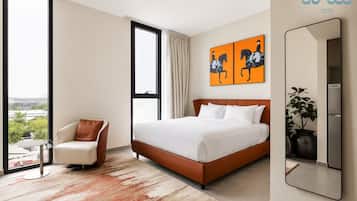 A hotel room with a large bed, a chair, a window, and a painting on the wall.