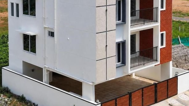 Un edificio residencial de varios pisos con techo plano, balcones y un tanque de agua visible en el techo.
