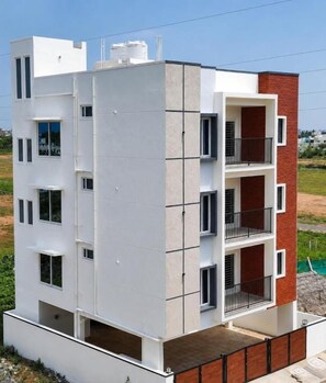 Un edificio residencial de varios pisos con techo plano, balcones y un tanque de agua visible en el techo.