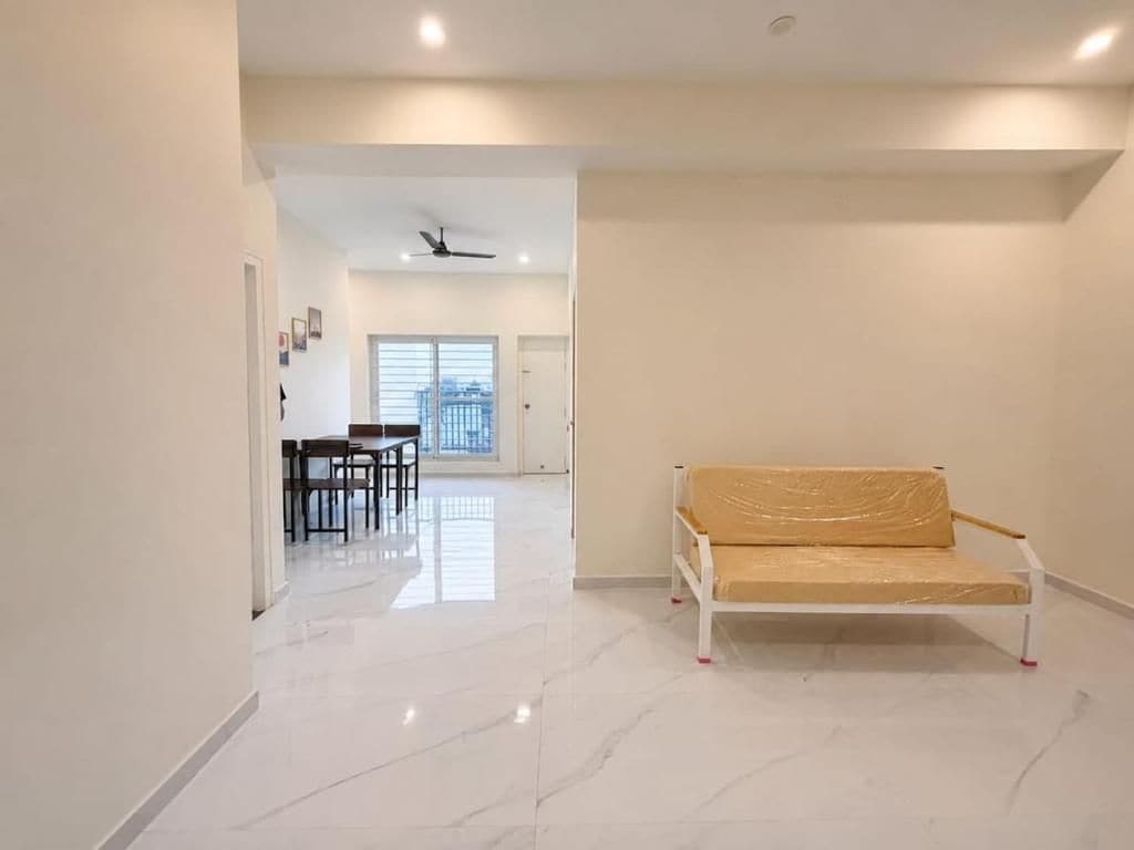 A spacious hallway with a white sofa, a dining area, and a ceiling fan.