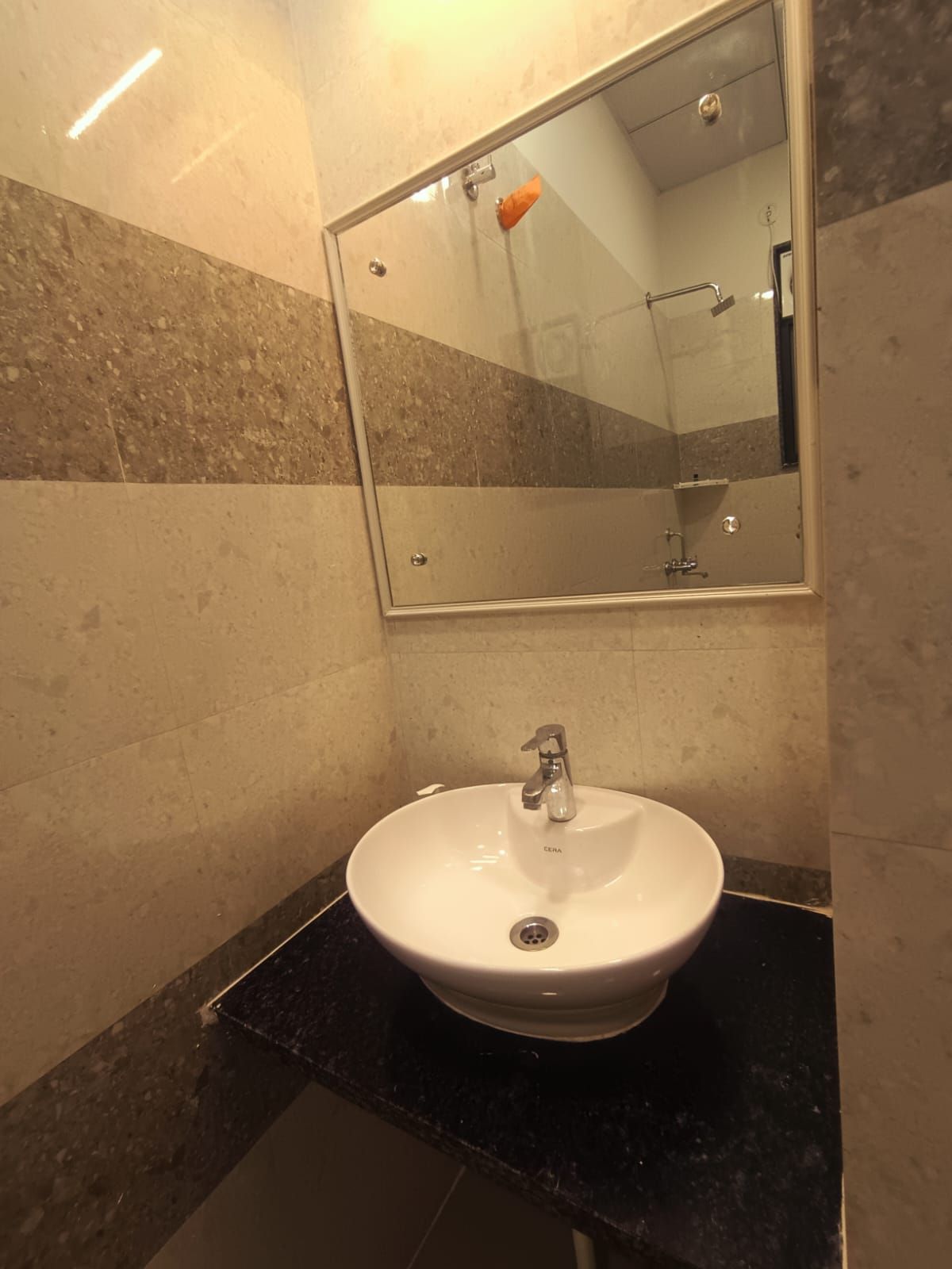 Un baño con un lavamanos blanco, un espejo y una zona de ducha.