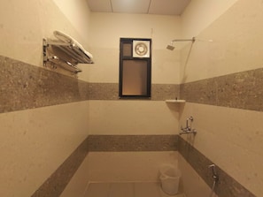 Un baño pequeño con azulejos, una ducha, un perchero y una ventana.