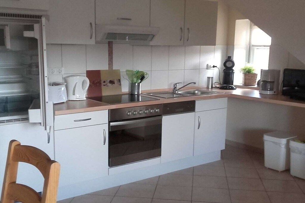 A compact kitchen with a built-in oven, a coffee maker, and a sink.
