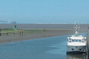 Un bateau sur une rivière, avec une rive éloignée.