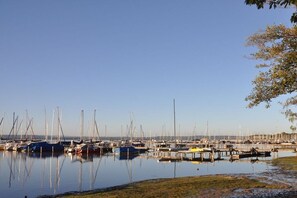 Un port de plaisance où sont amarrés de nombreux bateaux, avec une eau calme et un ciel dégagé.