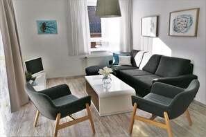Un salon moderne comprenant un canapé, une table basse et un téléviseur.