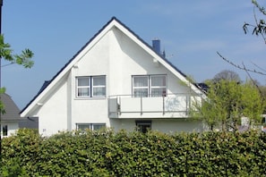 A two-story residential building with a gabled roof, a balcony on the upper floor, and a number '21' on the facade. - Holiday apartment in Scharbeutz with Wi-Fi (Scharbeutz)