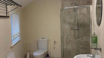 Un baño con inodoro, ducha y lavamanos.