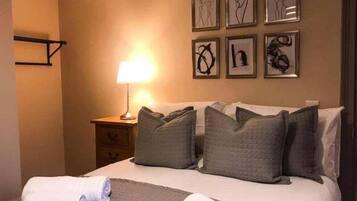 Una habitación de hotel con una cama, una mesita de noche, una lámpara y decoración en la pared.