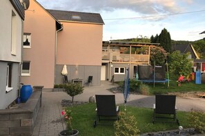 A residential backyard with a covered patio, outdoor seating, and a trampoline. - Holiday apartment with 2 bedrooms (Bernkastel-Andel)