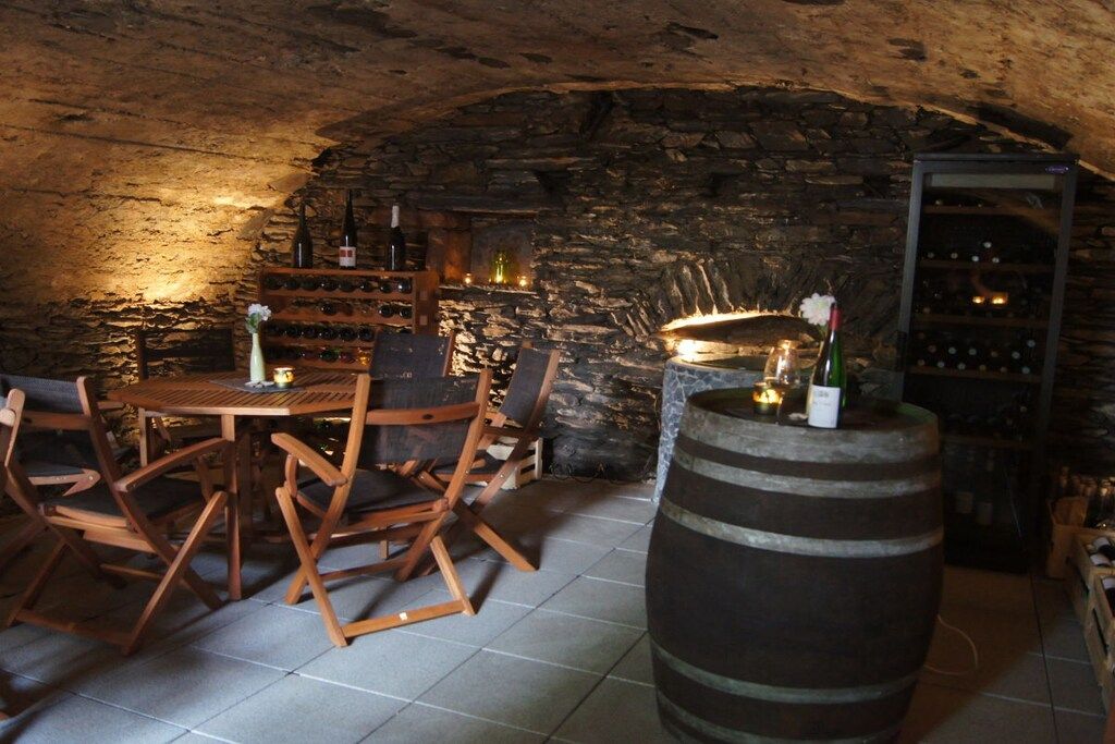 Une cave rustique, avec des meubles en bois, un meuble à bouteilles et un tonneau.